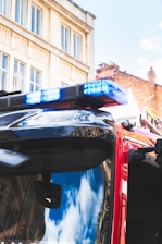 black and blue car in front of red car