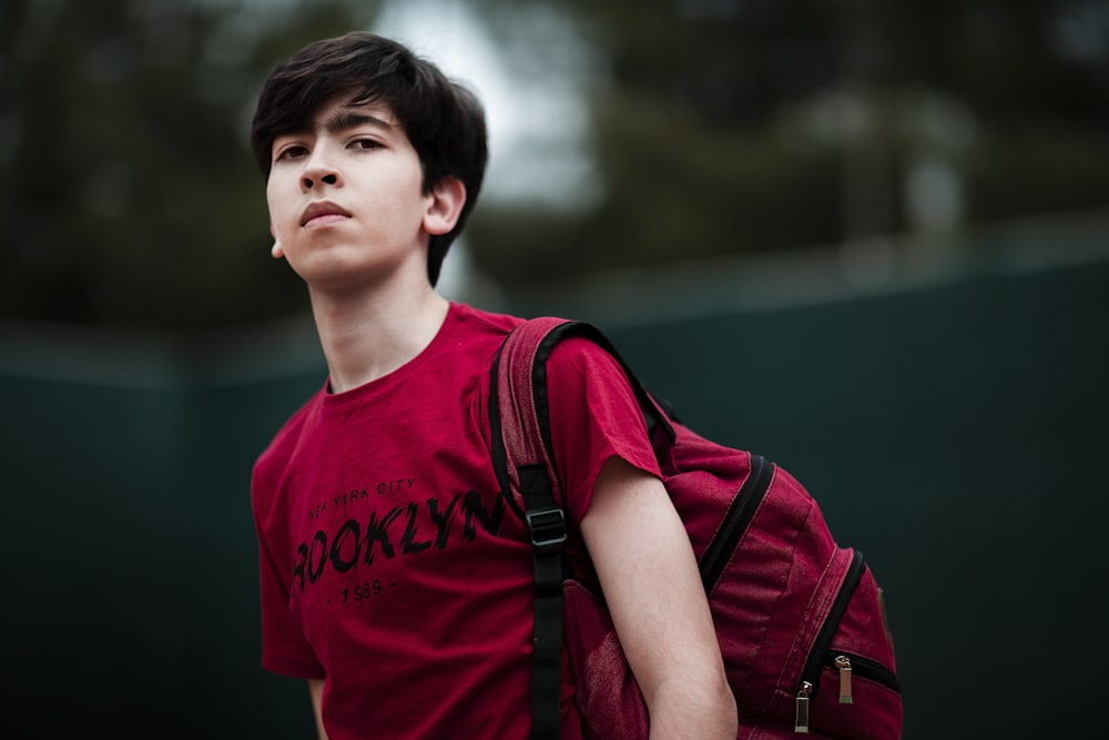 man in red crew neck t-shirt with black and red backpack