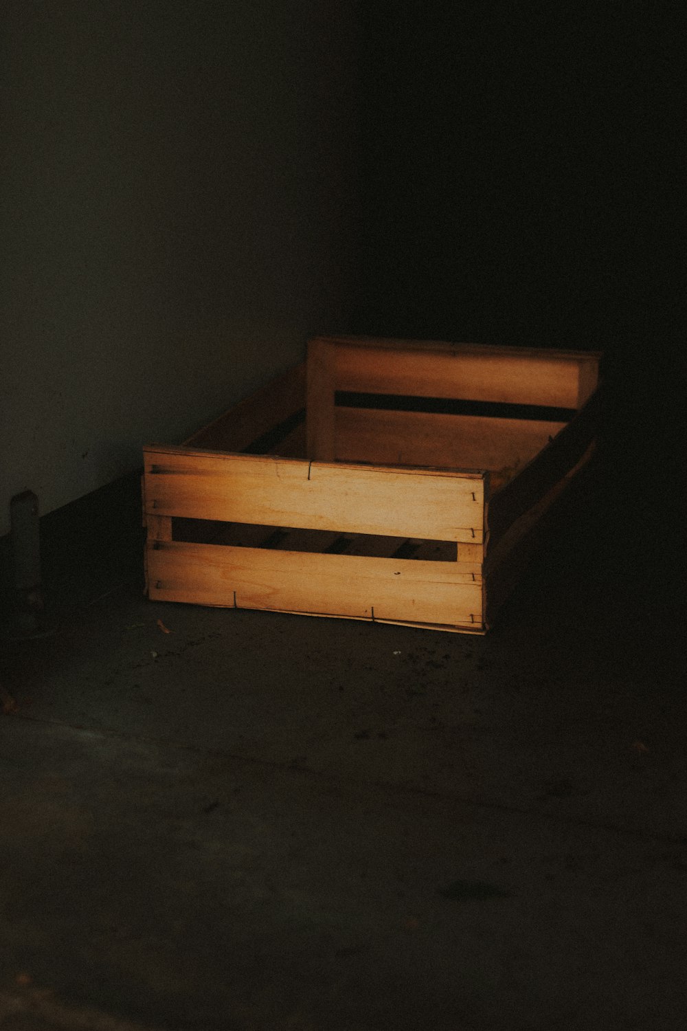 brown wooden bench beside white wall