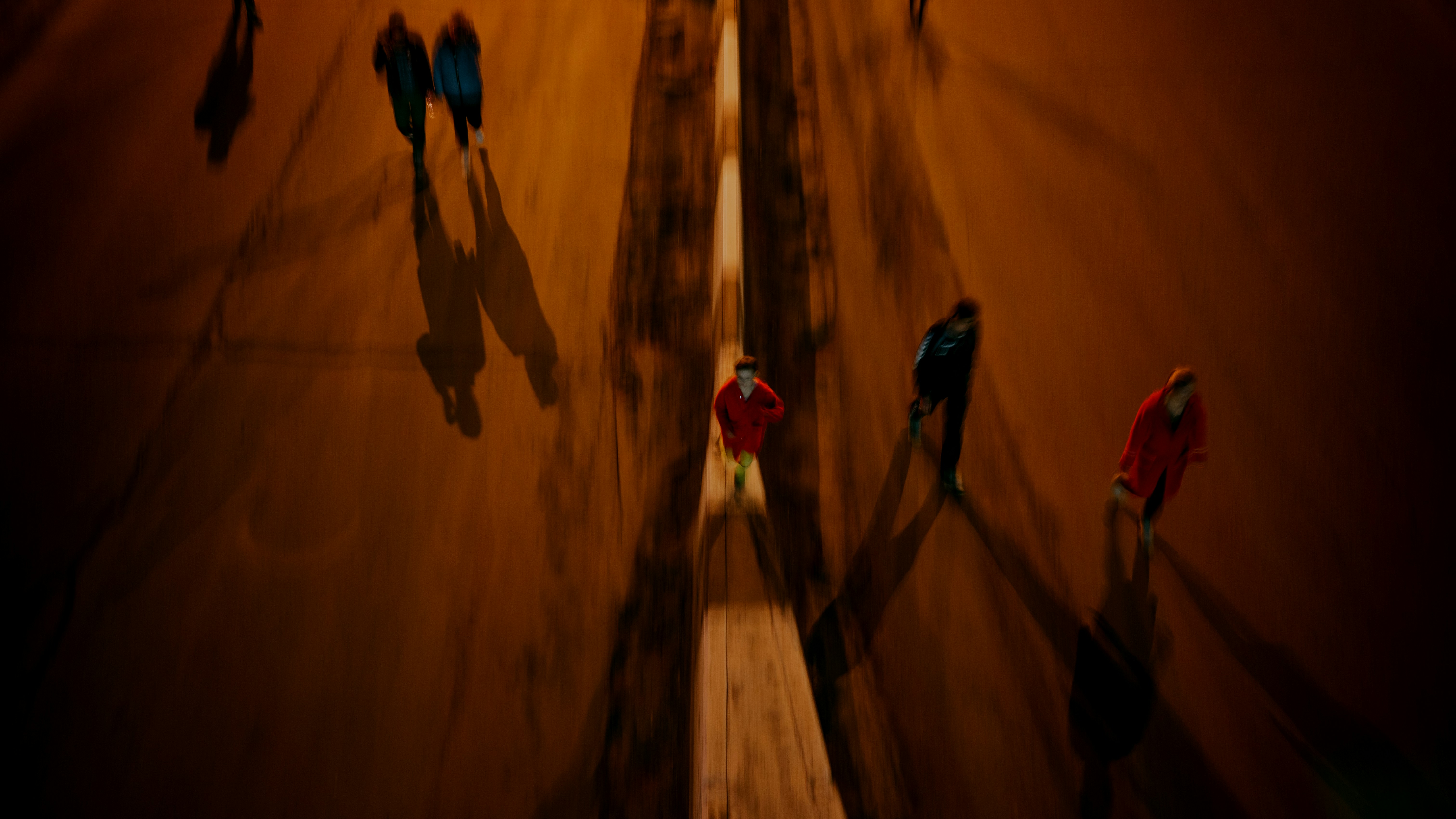 3 women in black pants and red jacket walking on brown sand
