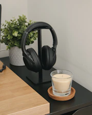 A peaceful scene of headphones resting on a Bible beside a glowing candle.