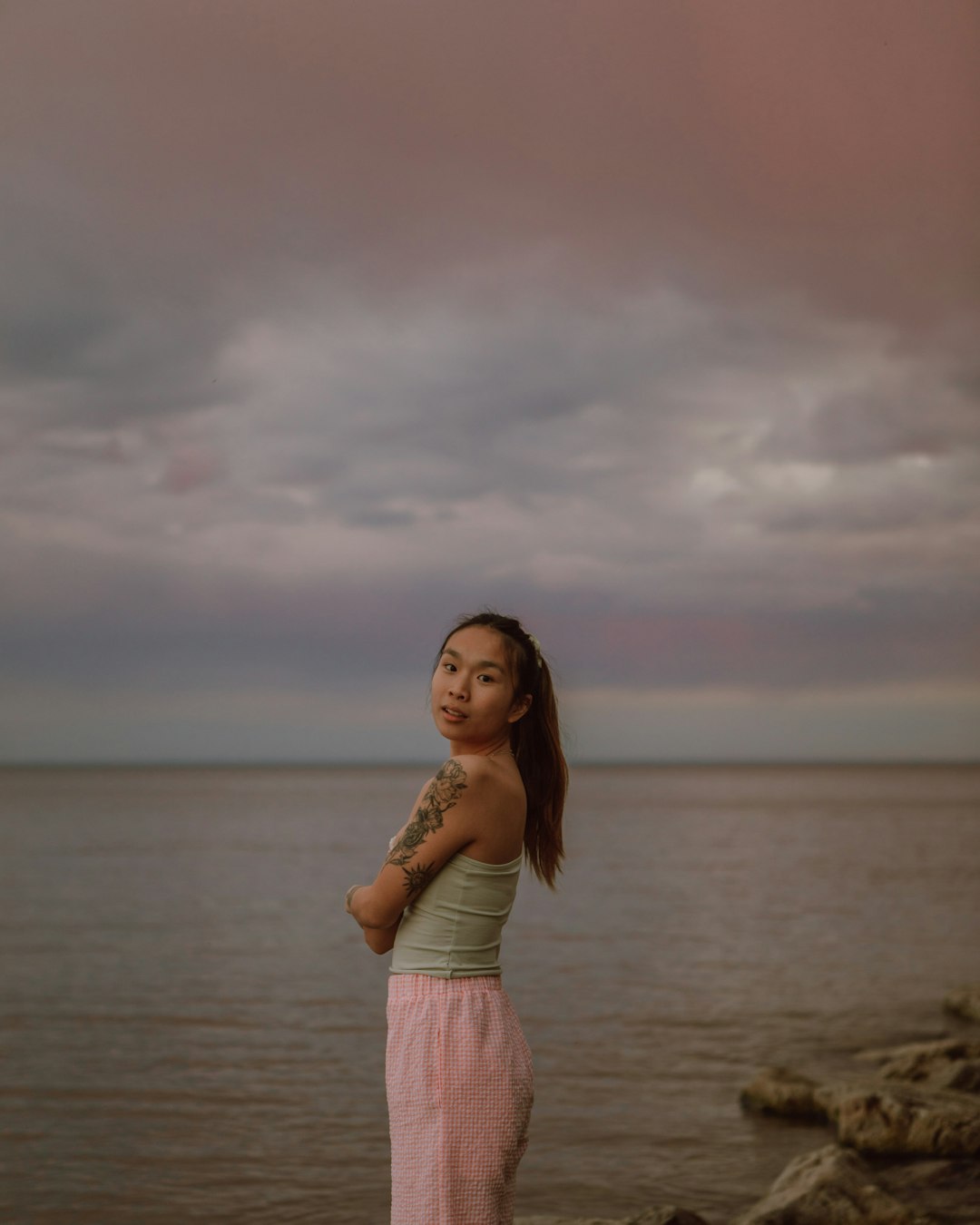 woman in pink dress standing on beach during daytime