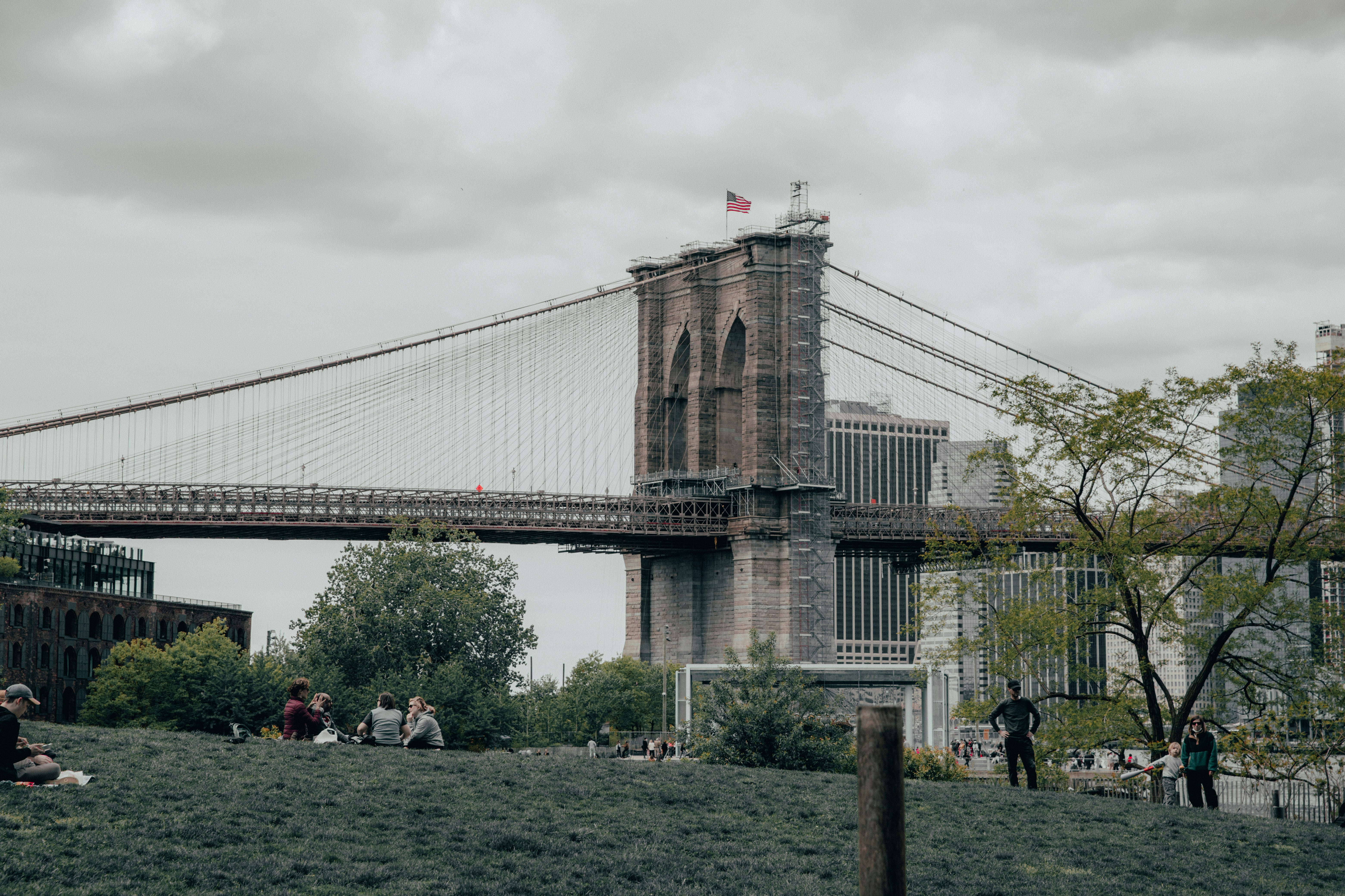 people walking on green grass field near bridge during daytime