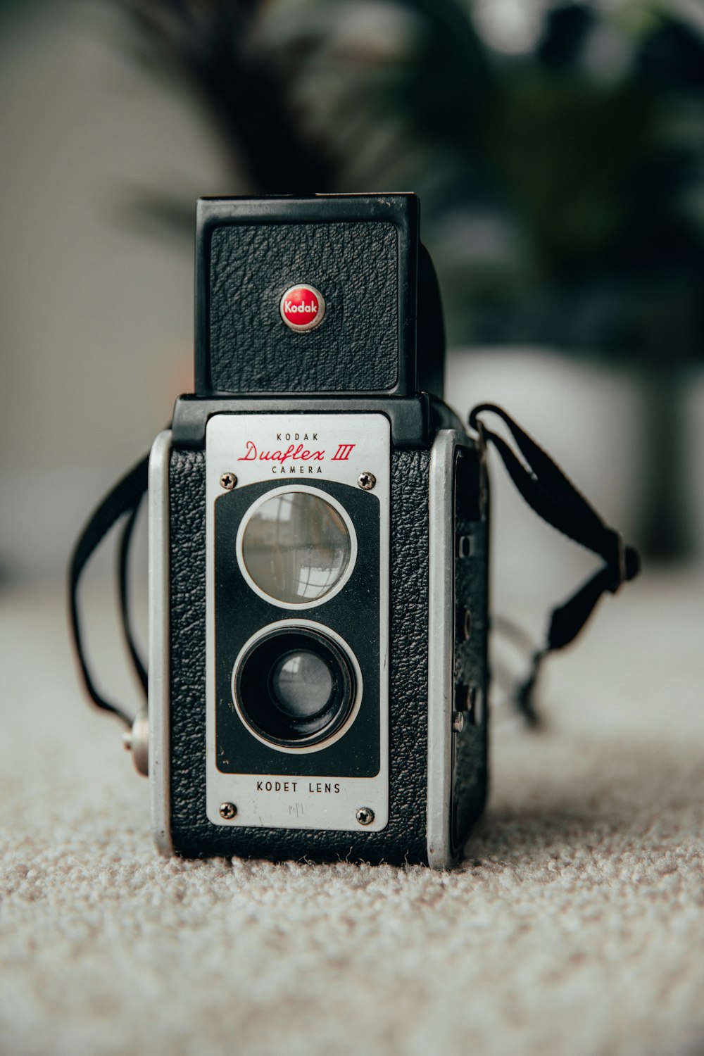 schwarz-silberne Pentax-Kamera auf braunem Textil