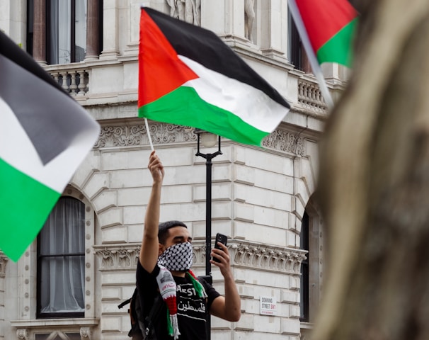 man in black t-shirt holding flag of india during daytime