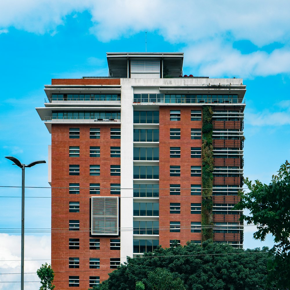 Edificio de hormigón marrón y blanco bajo el cielo azul durante el día