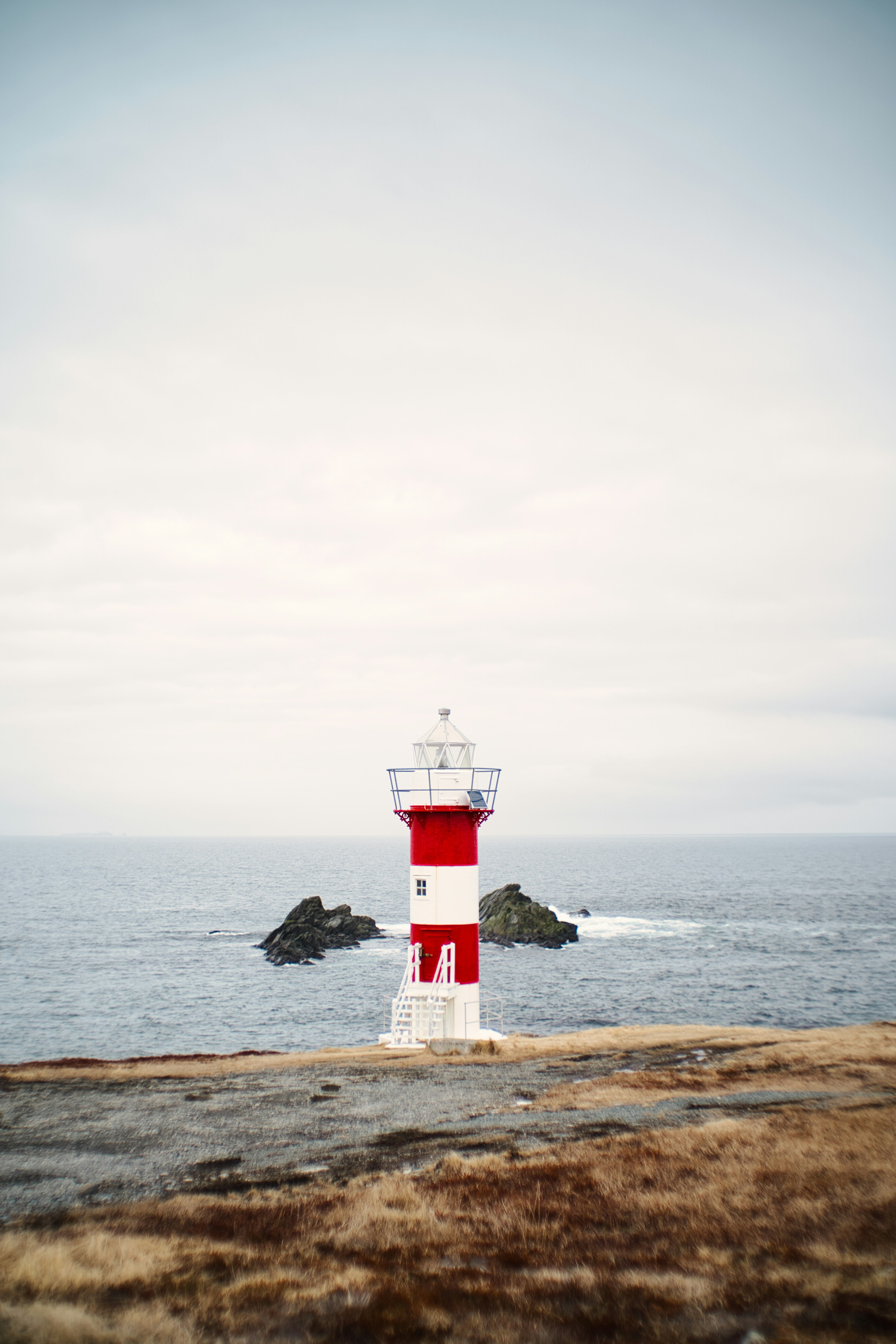 red and white lighthouse near body of water during daytime