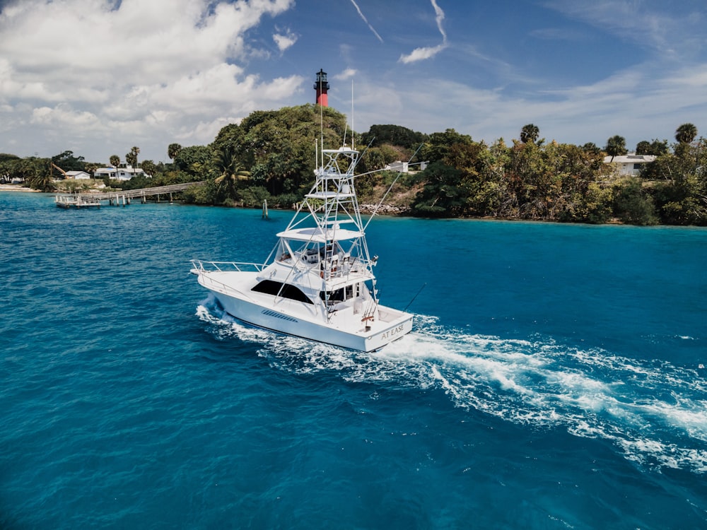 white and blue yacht on sea during daytime