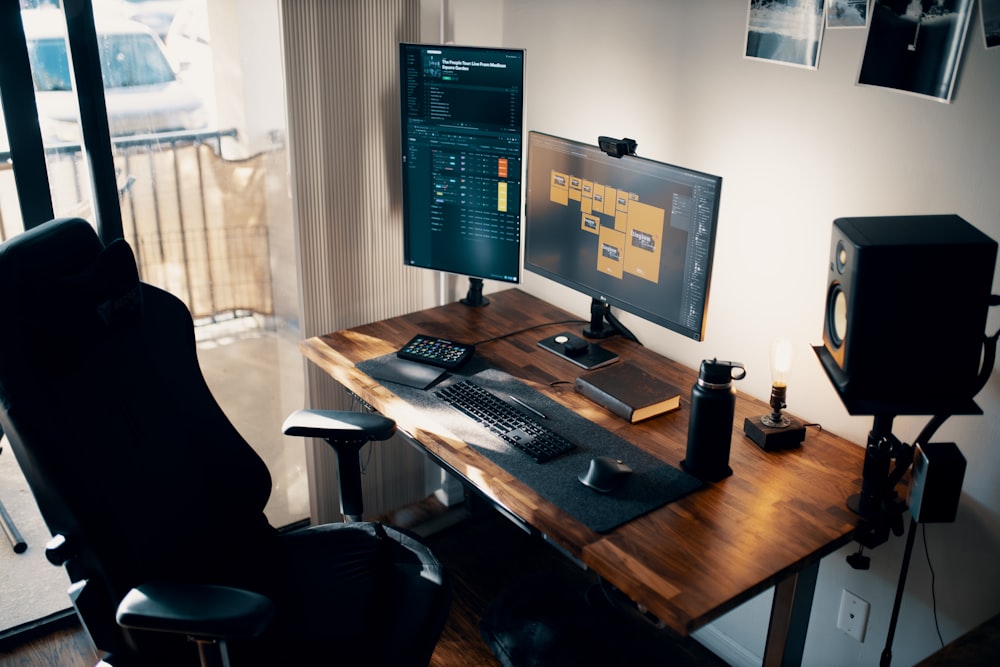 black flat screen computer monitor on brown wooden desk