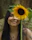 A candid shot of a person journaling with sunflower artwork nearby, symbolizing strength and acceptance.