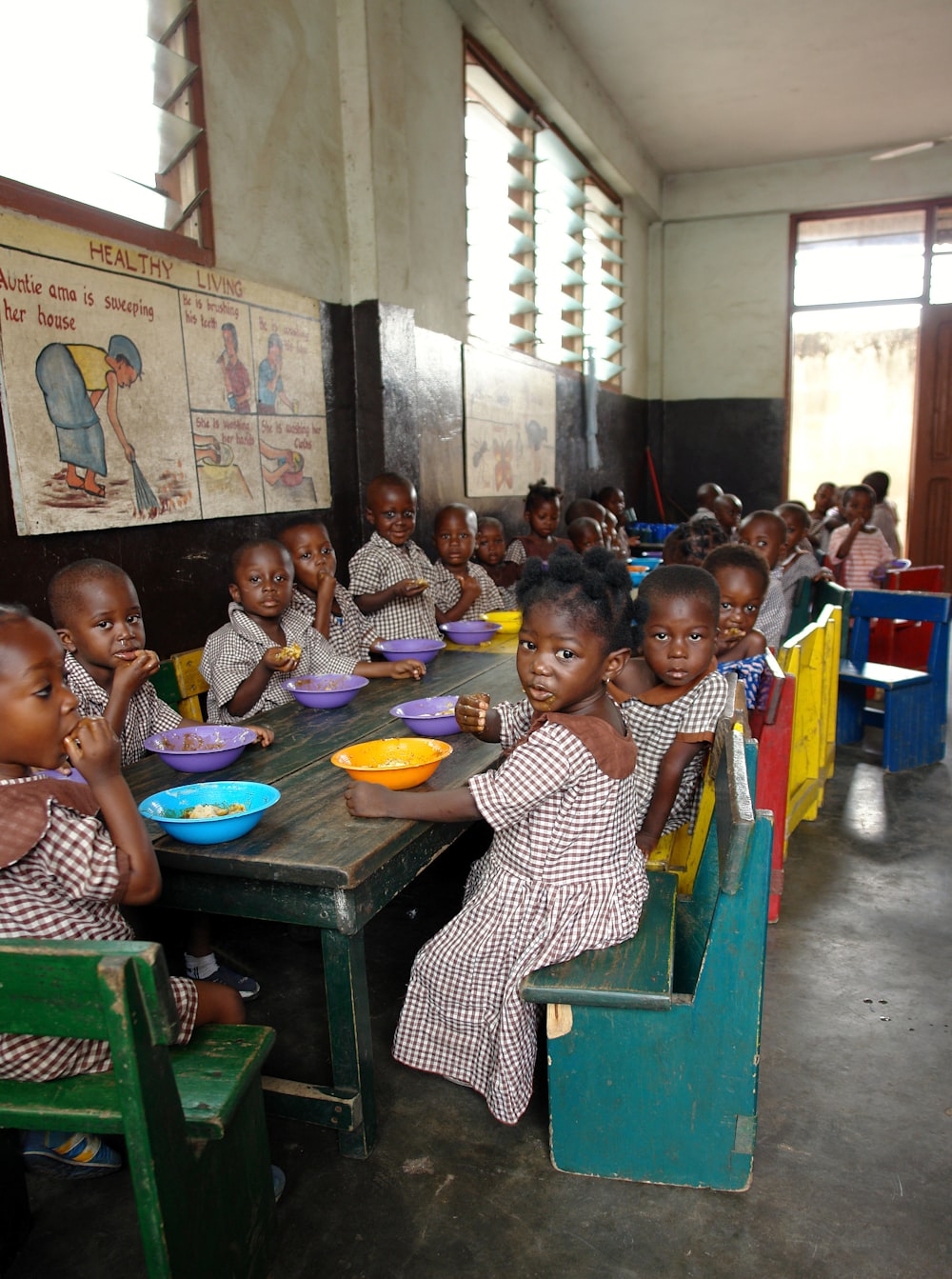 enfants assis sur une chaise verte mangeant