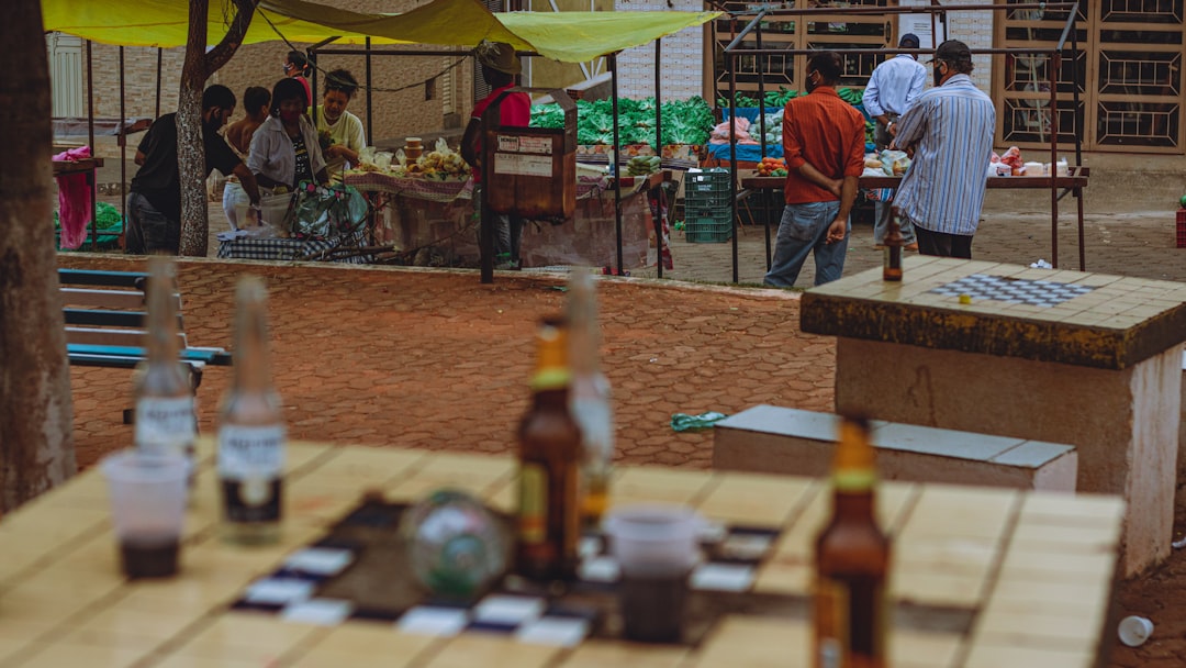 man in blue shirt standing near brown wooden table