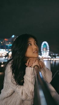 woman in white long sleeve shirt covering her face with her hand