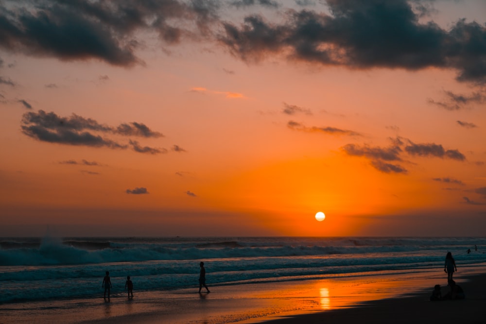 silhouette of people on beach during sunset