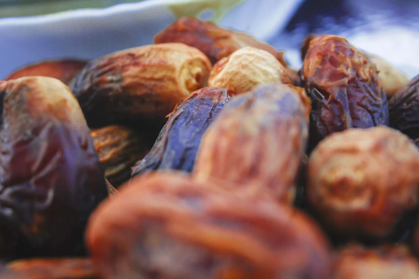Close-up of ripe dates glistening under soft light, highlighting their rich texture.