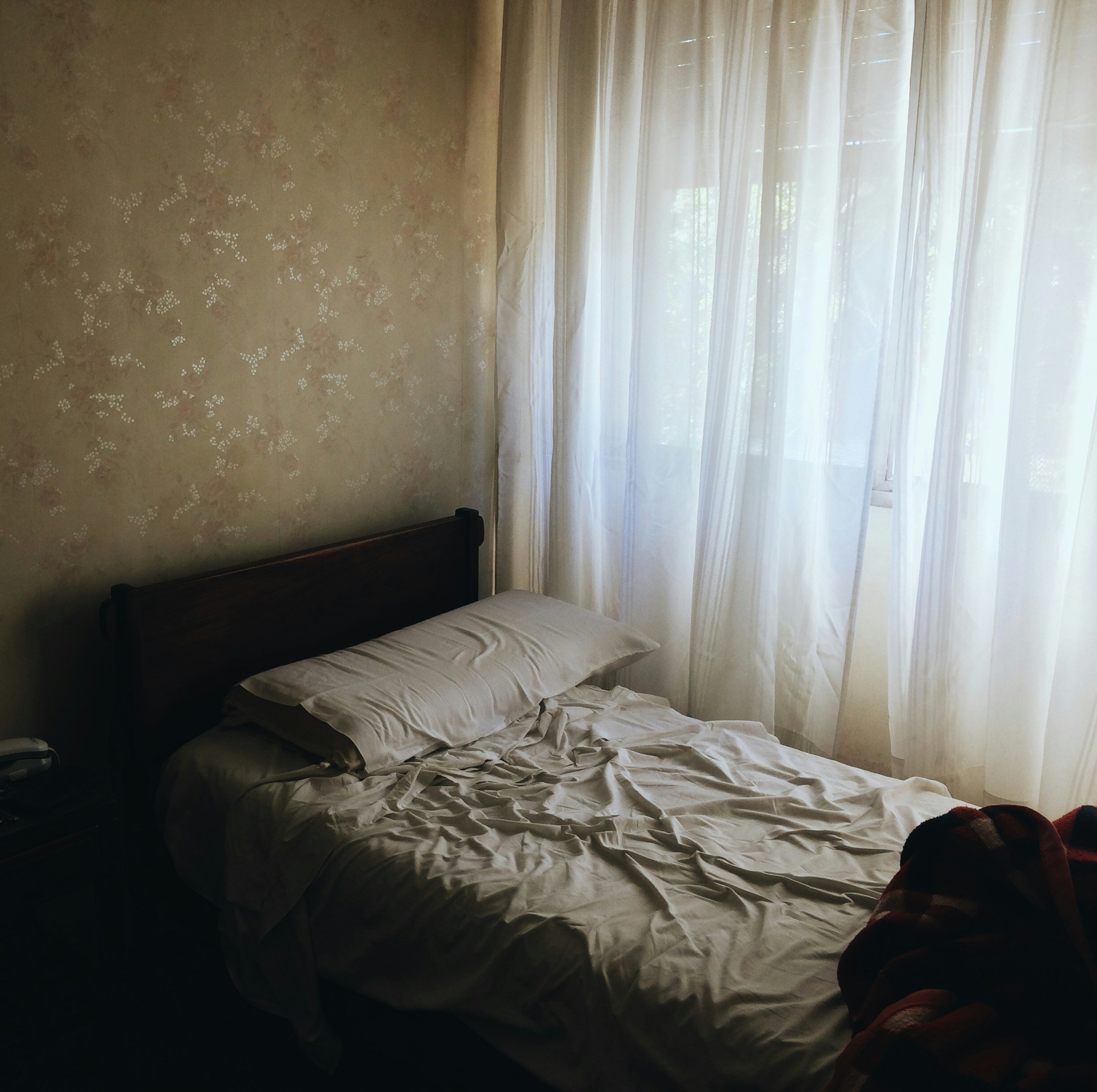 Bedroom in dim blue morning light, unmade bed, blinds half-open, quiet and restless atmosphere