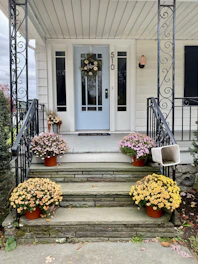 A welcoming front porch of a cozy house with a 'Welcome Home' mat.