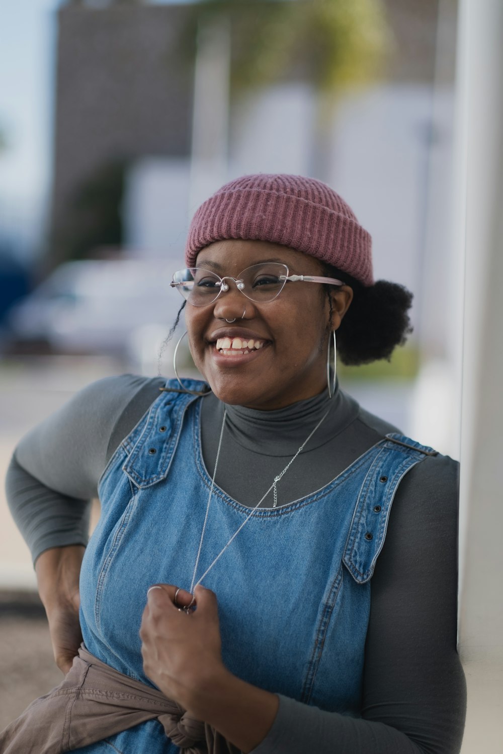 woman in blue denim vest and red knit cap