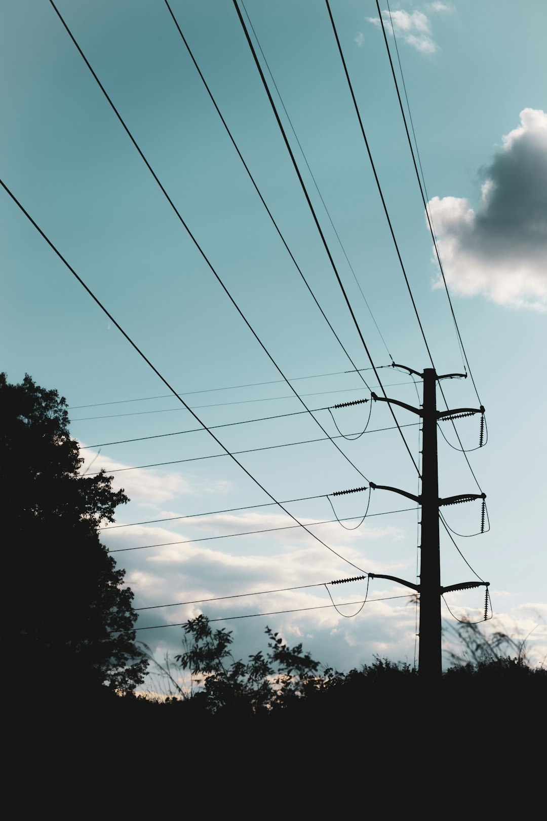 black electric post under blue sky during daytime