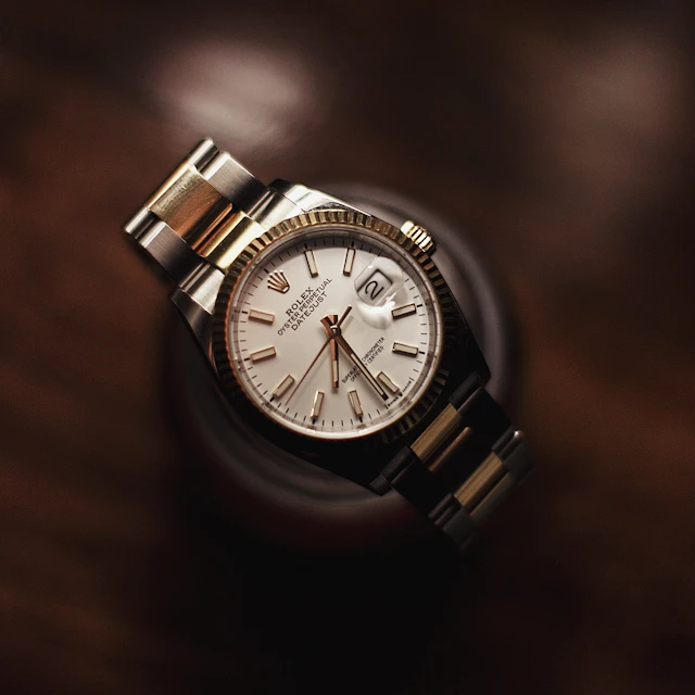 A silver wristwatch with a white dial photographed up close