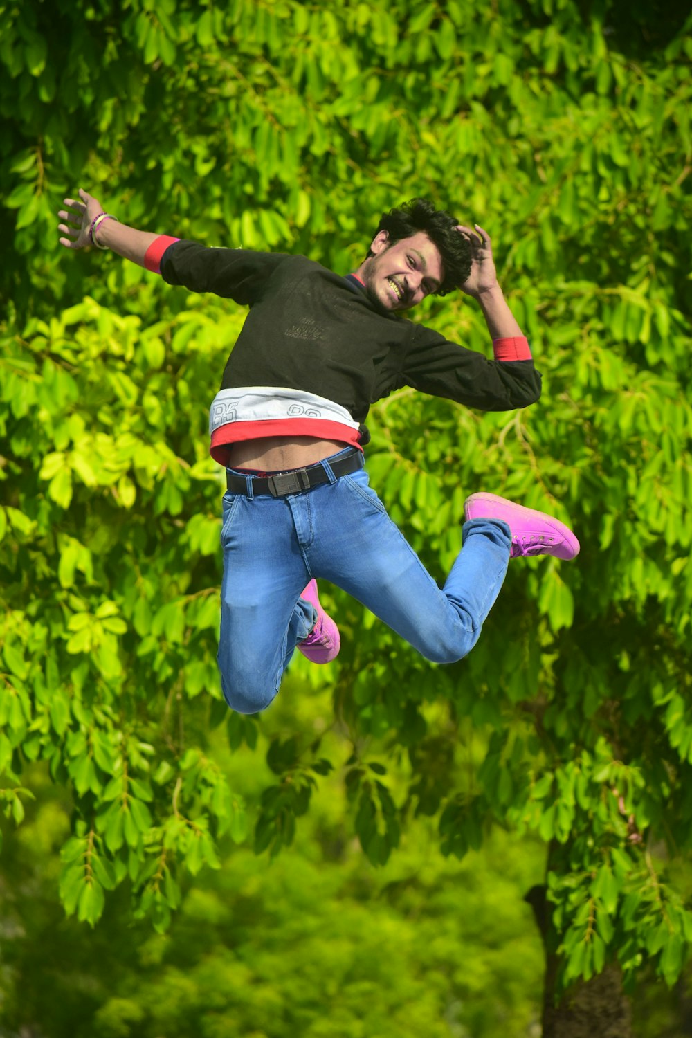 hombre con camisa negra de manga larga y jeans de mezclilla azul de pie en un campo de flores amarillas durante