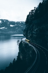 yellow car on road near body of water during daytime