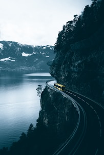 yellow car on road near body of water during daytime