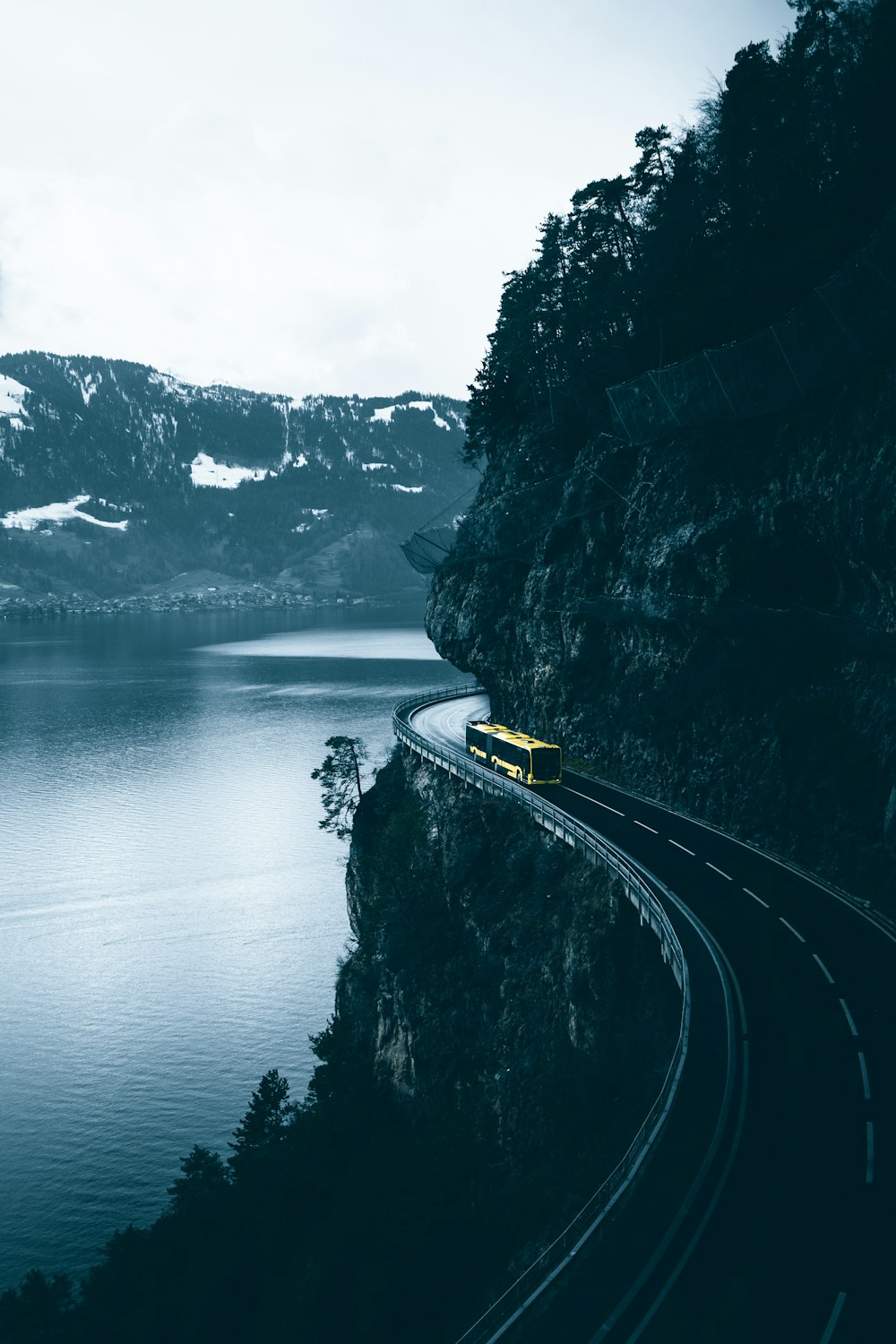 yellow car on road near body of water during daytime