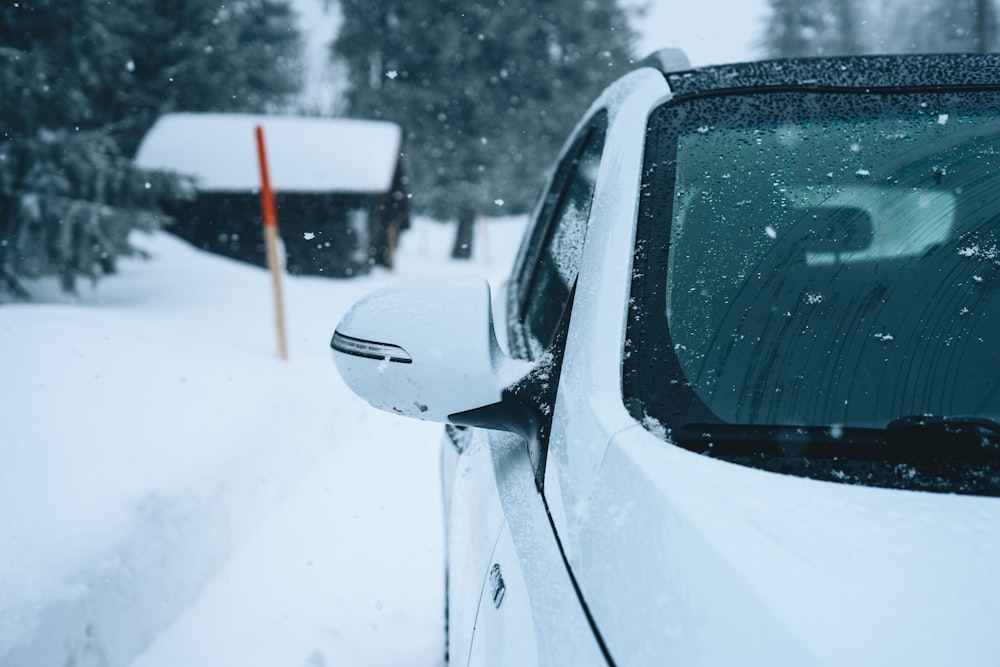 carro branco na estrada coberta de neve durante o dia