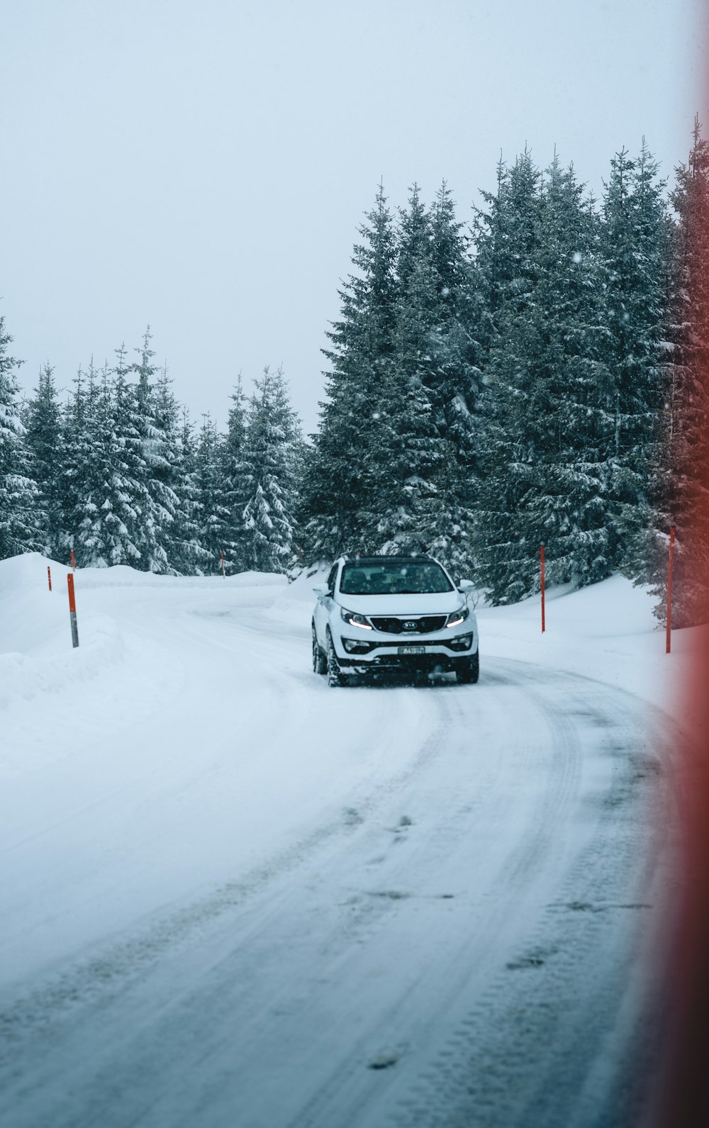 black car on road covered with snow during daytime