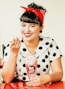 woman in white and black polka dot shirt holding red and white plastic cup