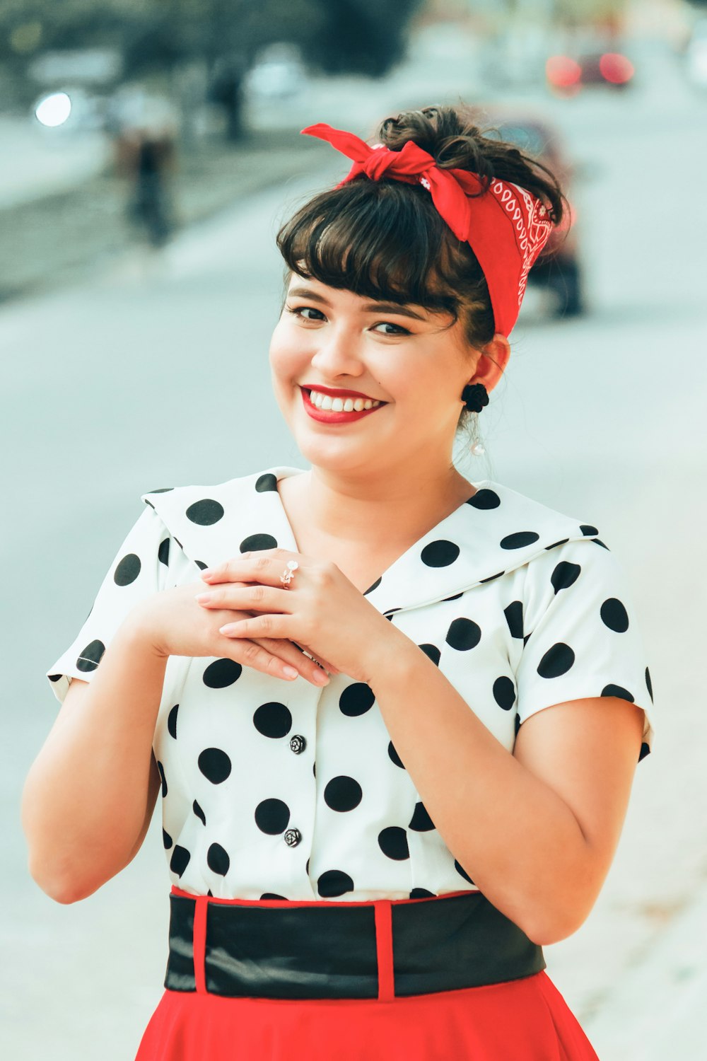 woman in white and black polka dot shirt holding white and black polka dot print ceramic