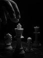 grayscale photo of person holding chess piece