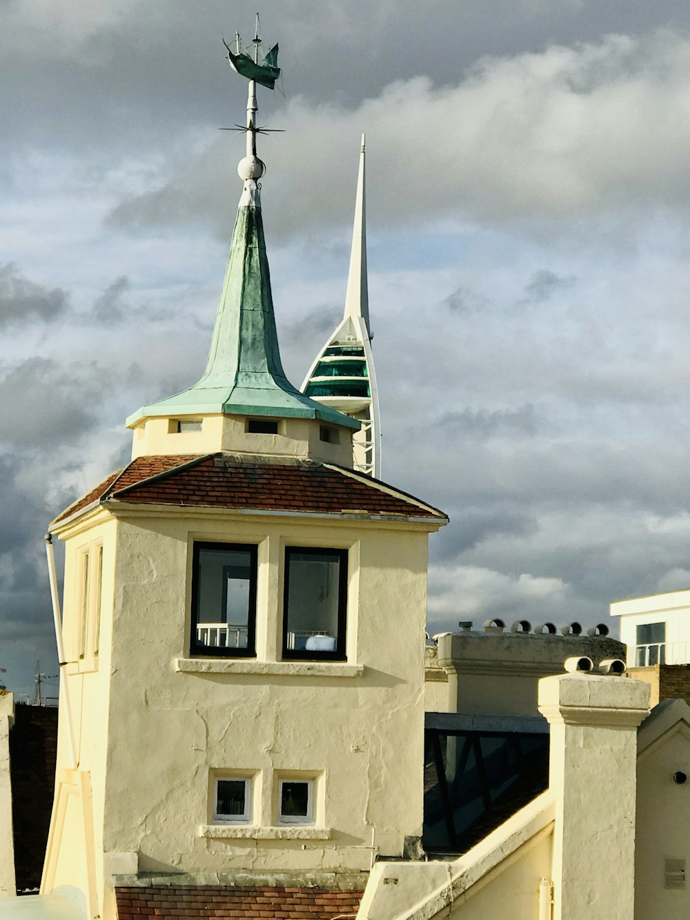 white and brown concrete building under white clouds during daytime