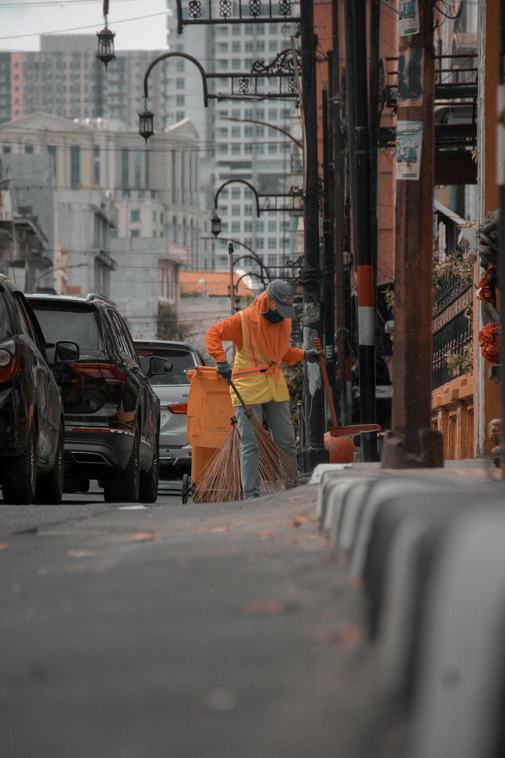 Hombre con chaqueta naranja caminando por la calle durante el día
