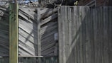 Technician inspecting a wooden fence for termite damage in a Fort Worth backyard.