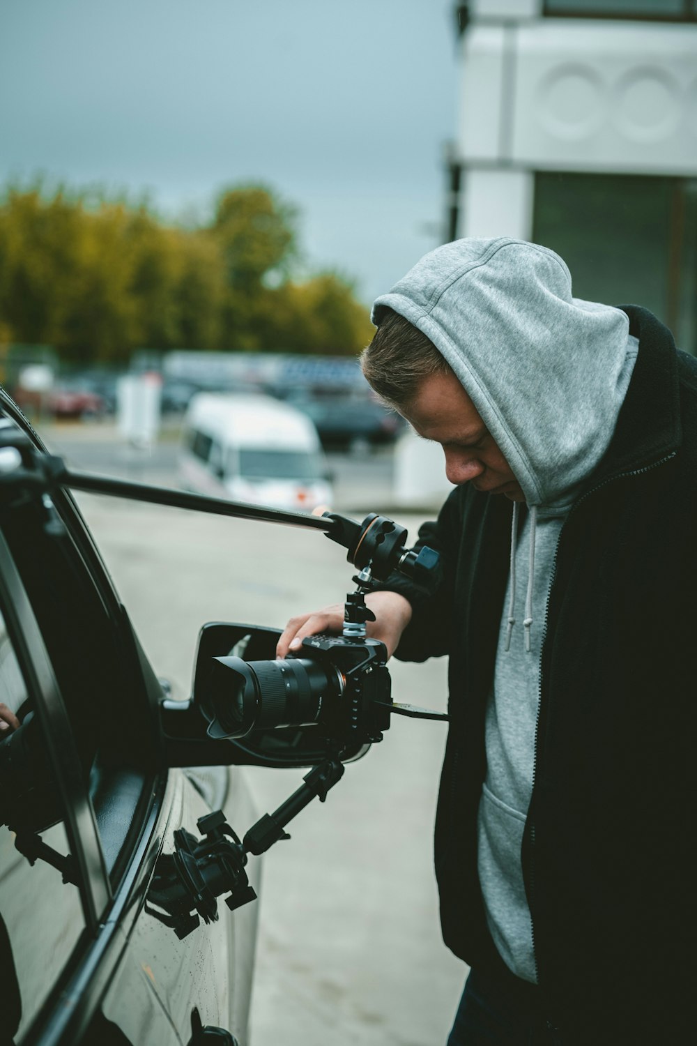 woman in gray hoodie holding black dslr camera