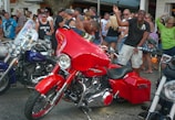 A vibrant community event with people gathered around dirt bikes.