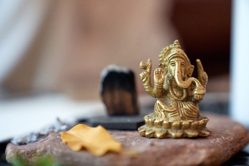 gold buddha figurine on white textile