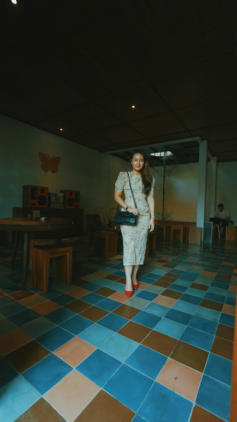 woman in white dress standing on brown and white floor tiles