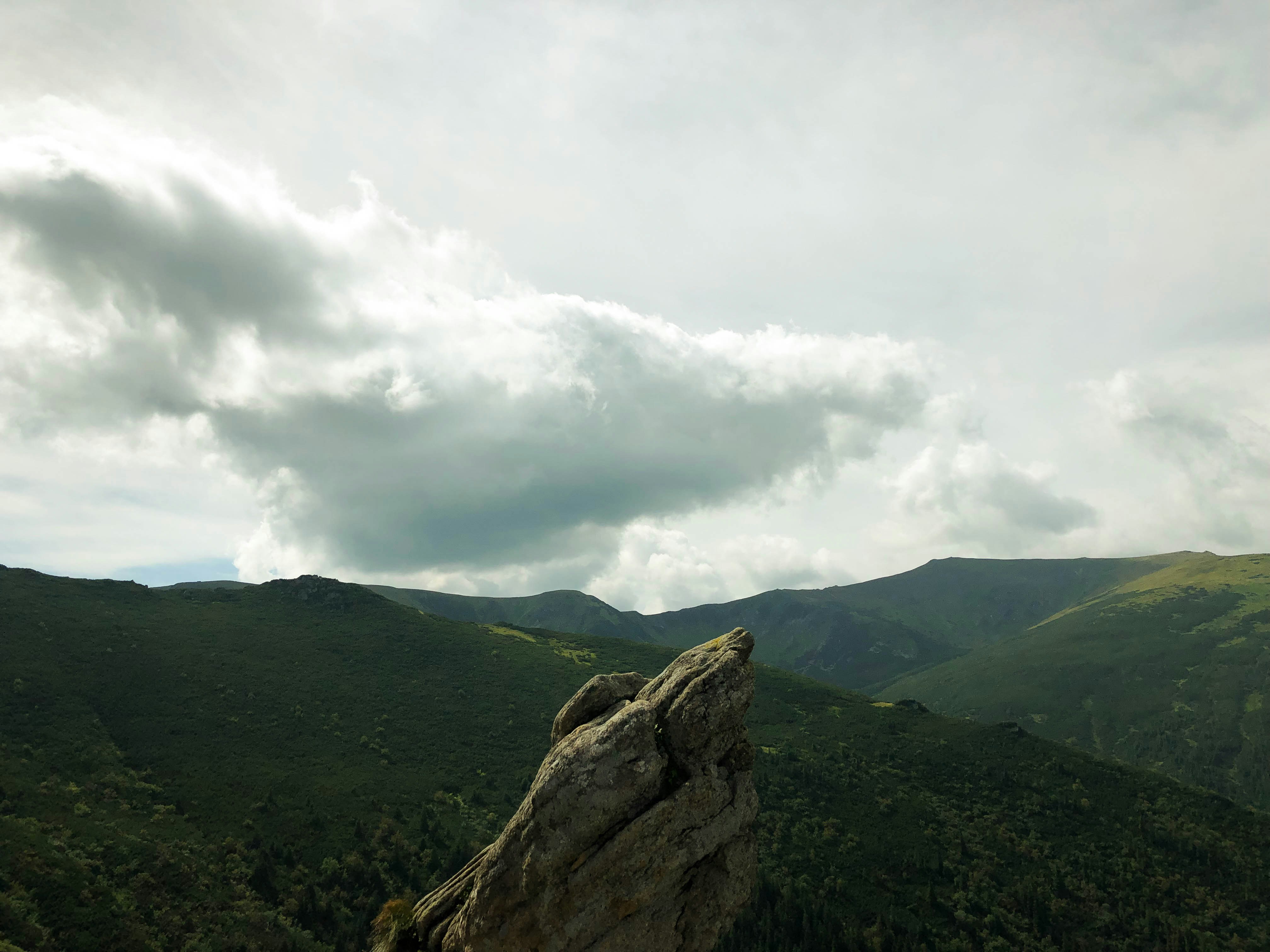 Montagne verte sous les nuages blancs pendant la journée
