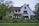 white and gray house near green grass field during daytime