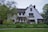 white and gray house near green grass field during daytime