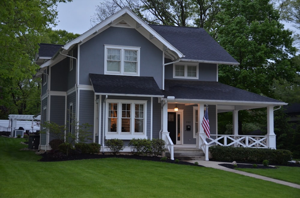 white and gray wooden house near green grass field during daytime