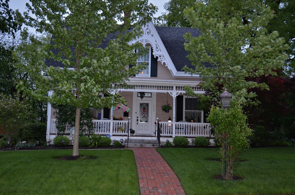 white and brown wooden house near green trees during daytime