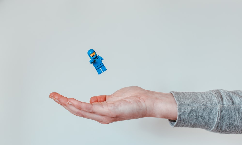 person holding blue lego toy