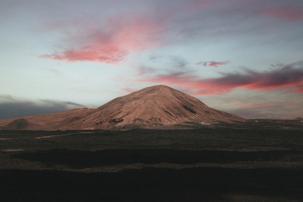 brown mountain under white clouds during daytime