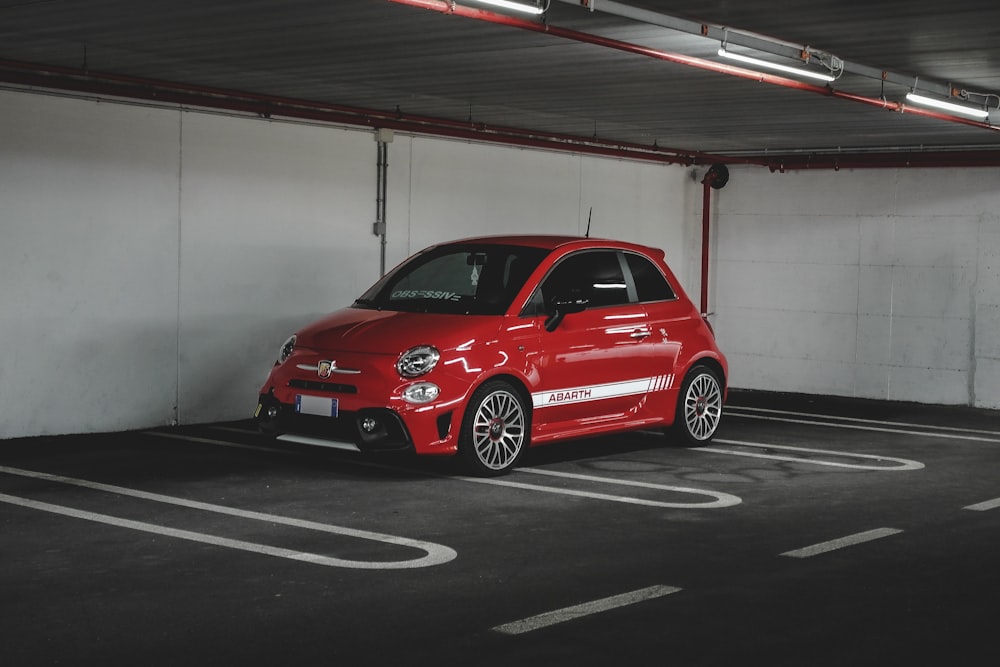 red 5 door hatchback parked on garage