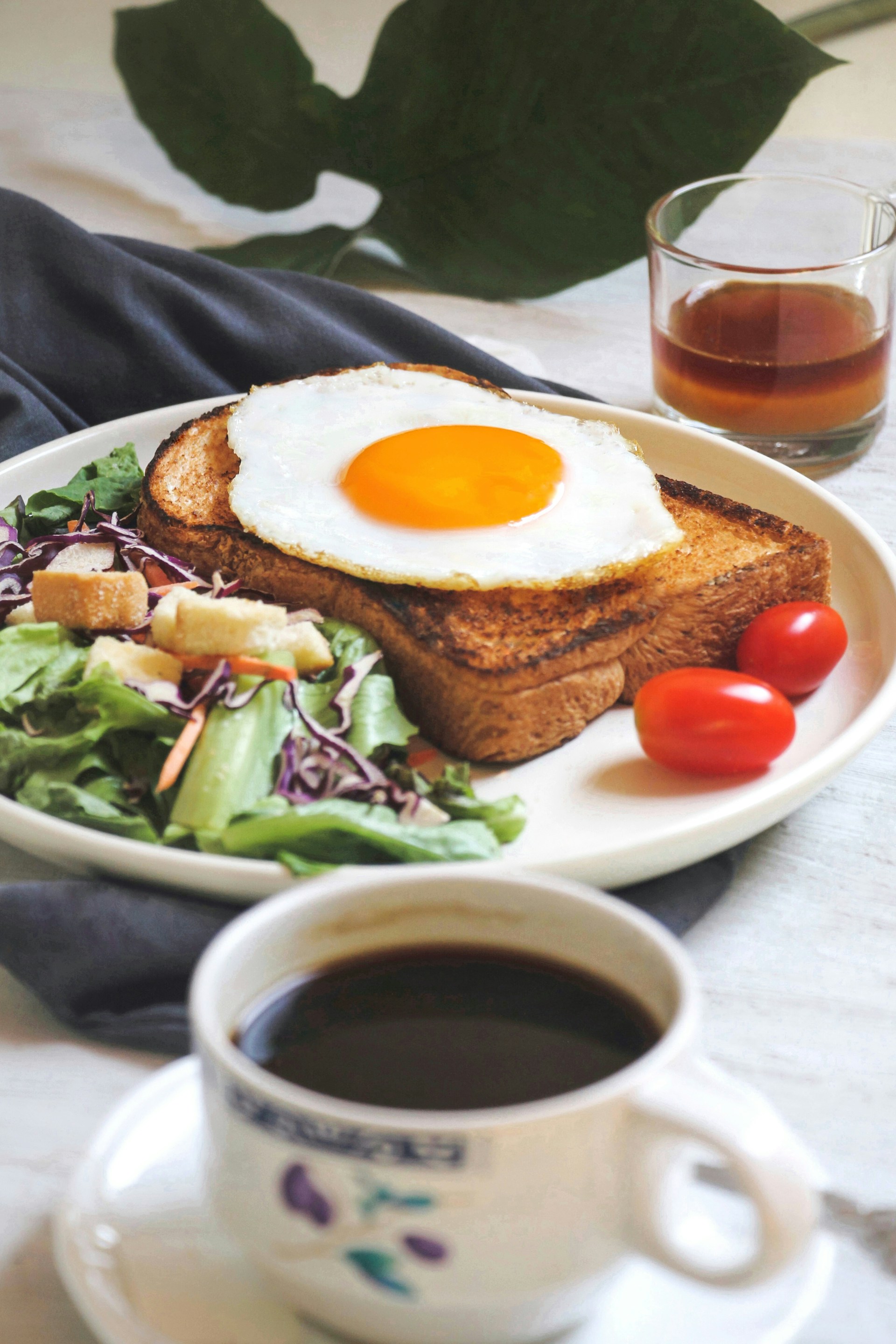 burger with egg and lettuce on white ceramic plate