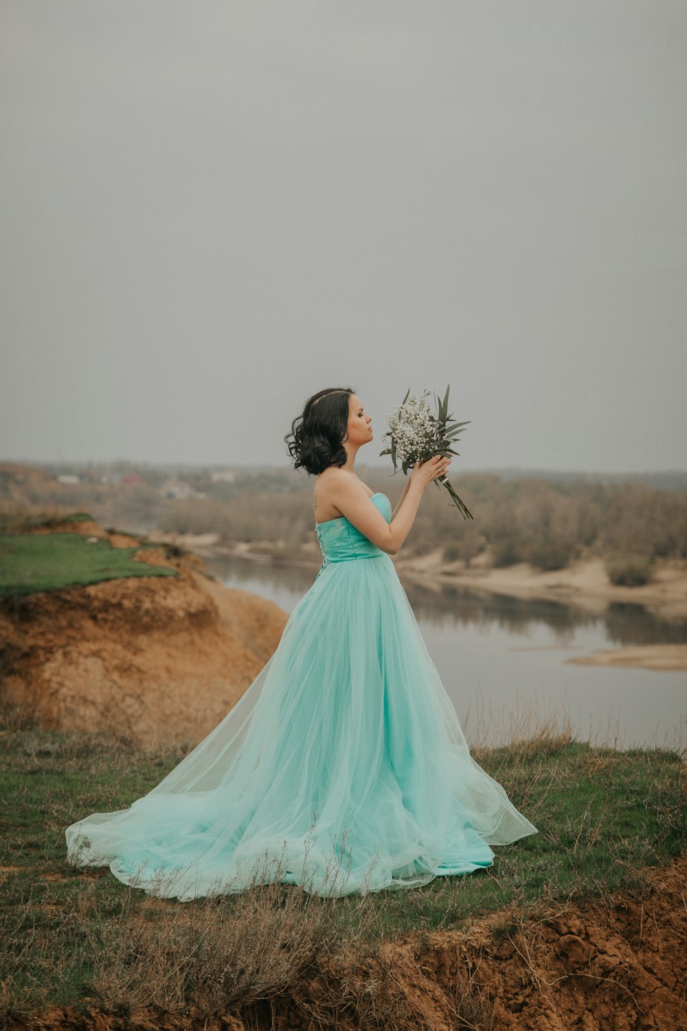 woman in white wedding dress standing on green grass field during daytime